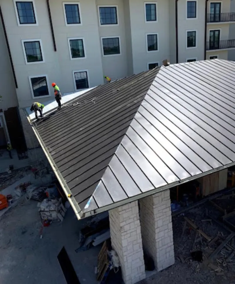 Crew installing standing seam metal roof panels on a commercial project in San Marino